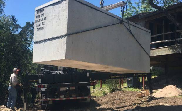 Large white prefabricated module being lifted by a crane at a construction site