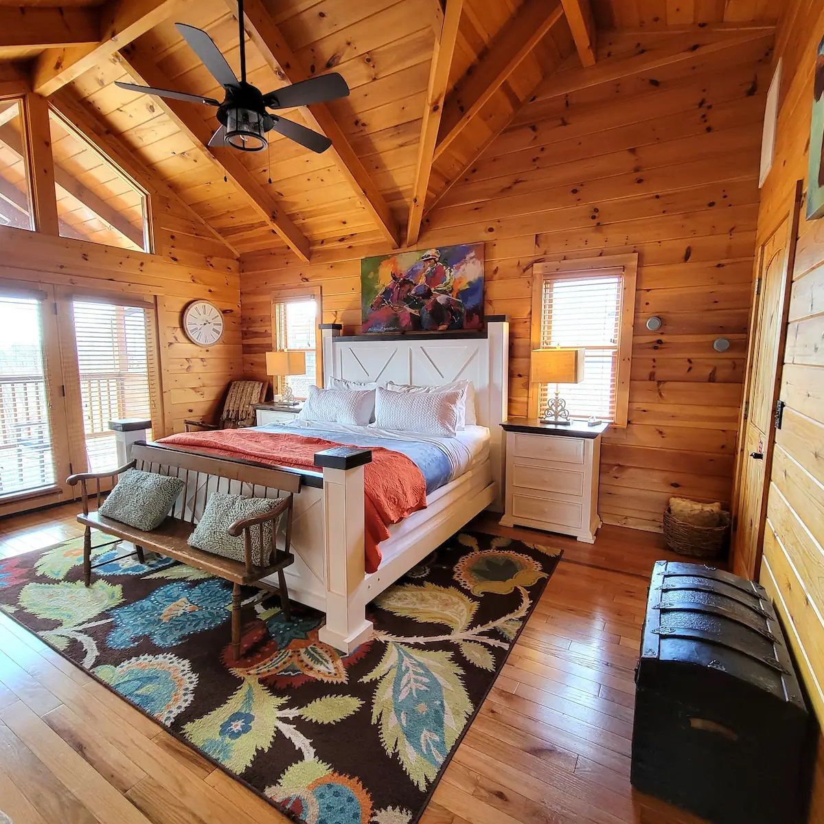 A bedroom in a log cabin with a ceiling fan