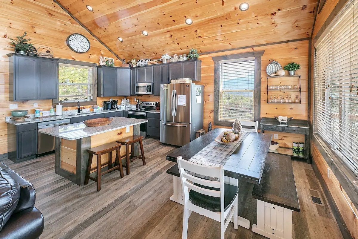 A kitchen and dining room in a log cabin with a table and chairs.