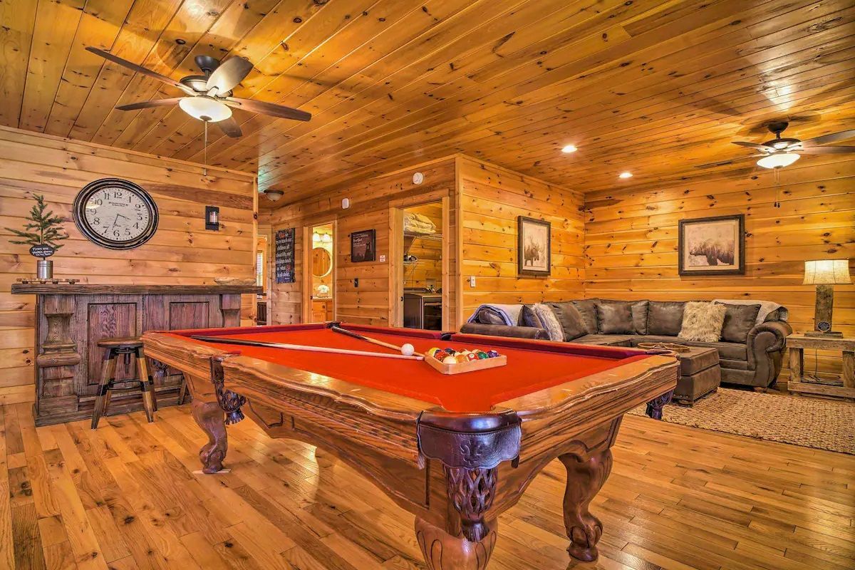 There is a pool table in the middle of the living room.