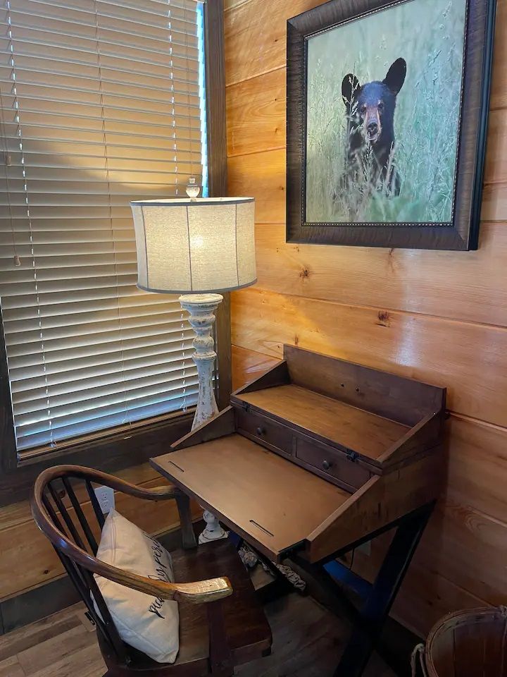 There is a picture of a bear on the wall above the desk.