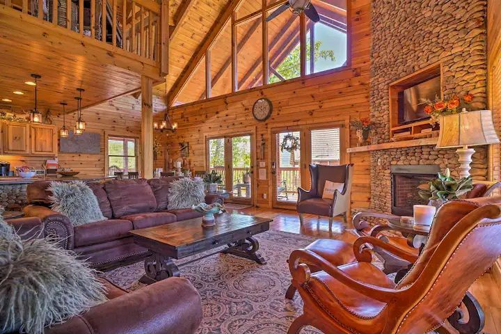 A living room filled with furniture and a fireplace in a log cabin.