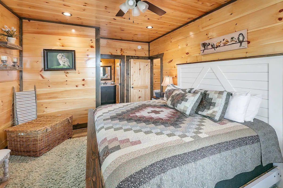 A bedroom with a king size bed and a ceiling fan.