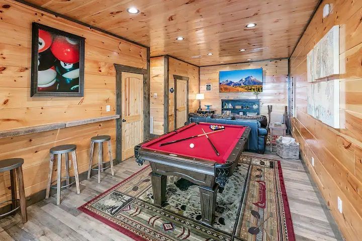 There is a pool table in the middle of the room.