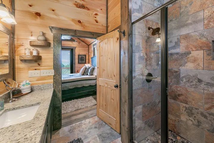A bathroom in a cabin with a walk in shower and a sink.
