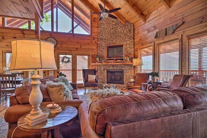 A living room filled with furniture and a fireplace in a log cabin.