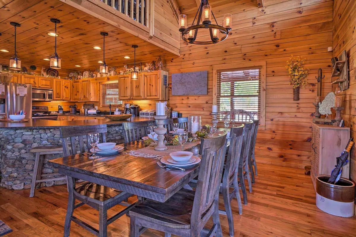 A dining room table and chairs in a log cabin.