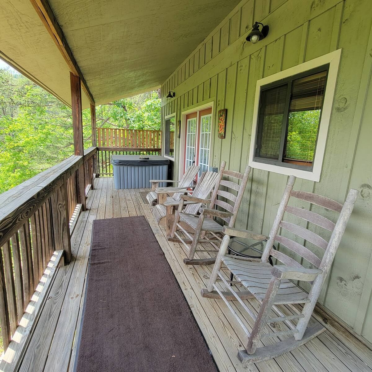There are rocking chairs on the porch of a house.