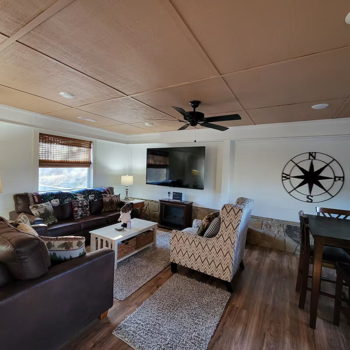 A living room with a ceiling fan and a compass on the wall.