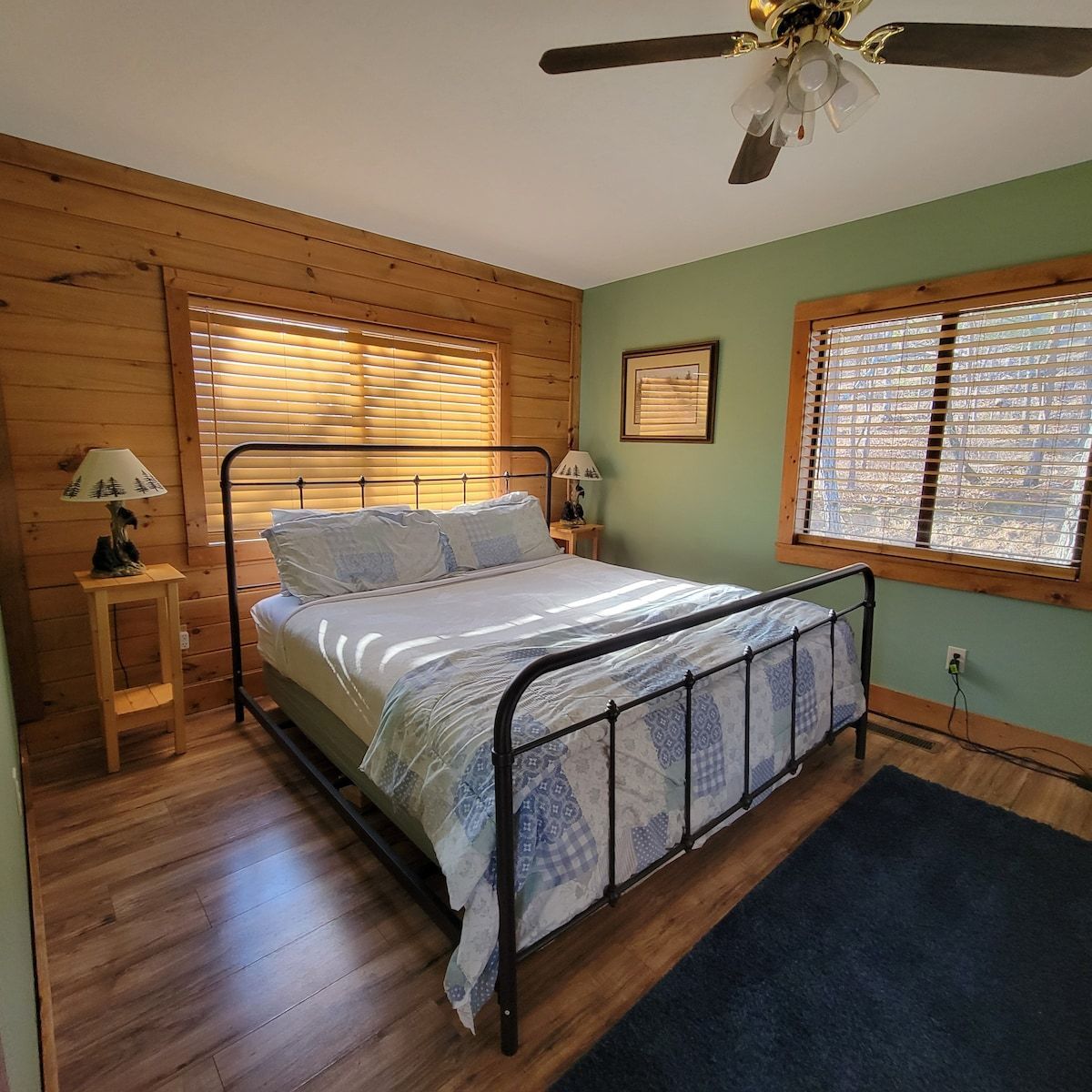 A bedroom with a bed and a ceiling fan