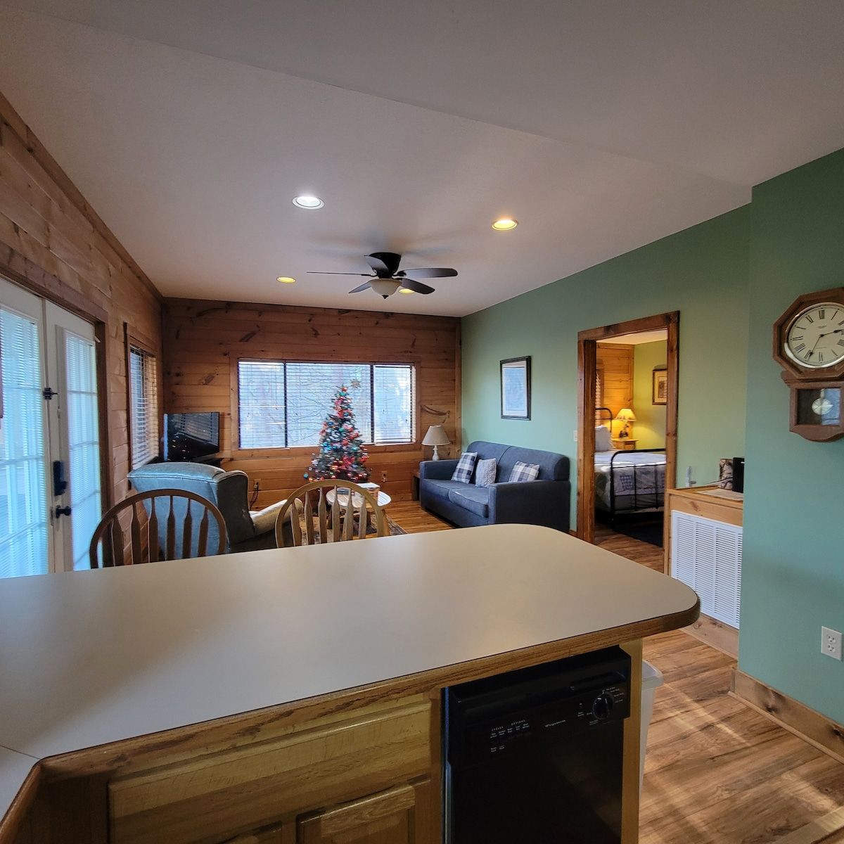 A living room with a couch and a clock on the wall