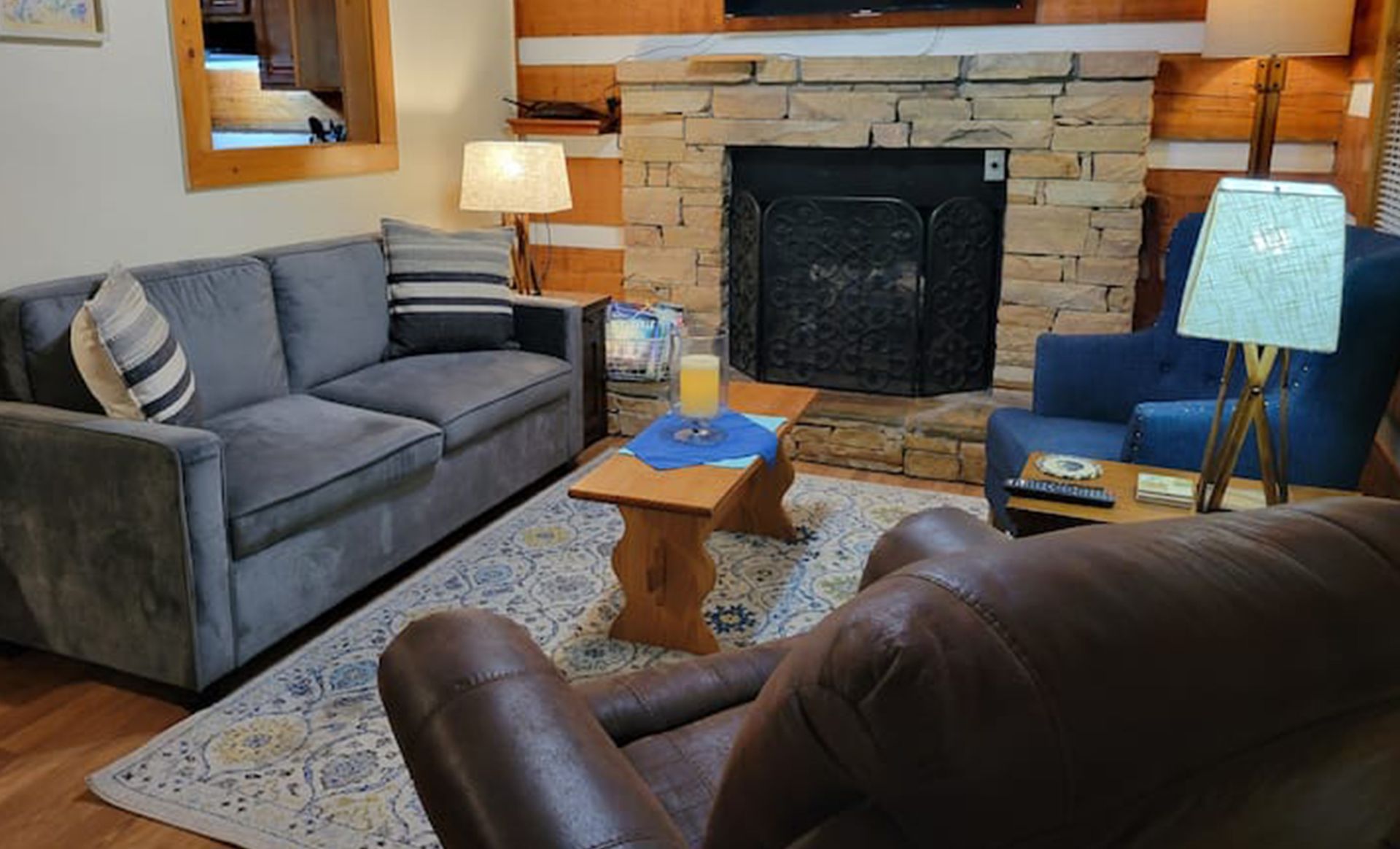 A living room with a couch , chair , coffee table and fireplace.