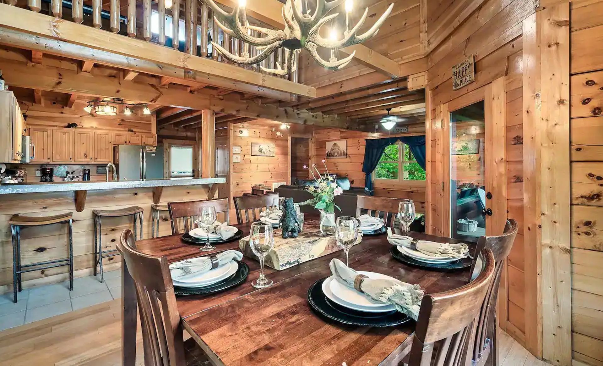 A dining room in a log cabin with a wooden table and chairs.