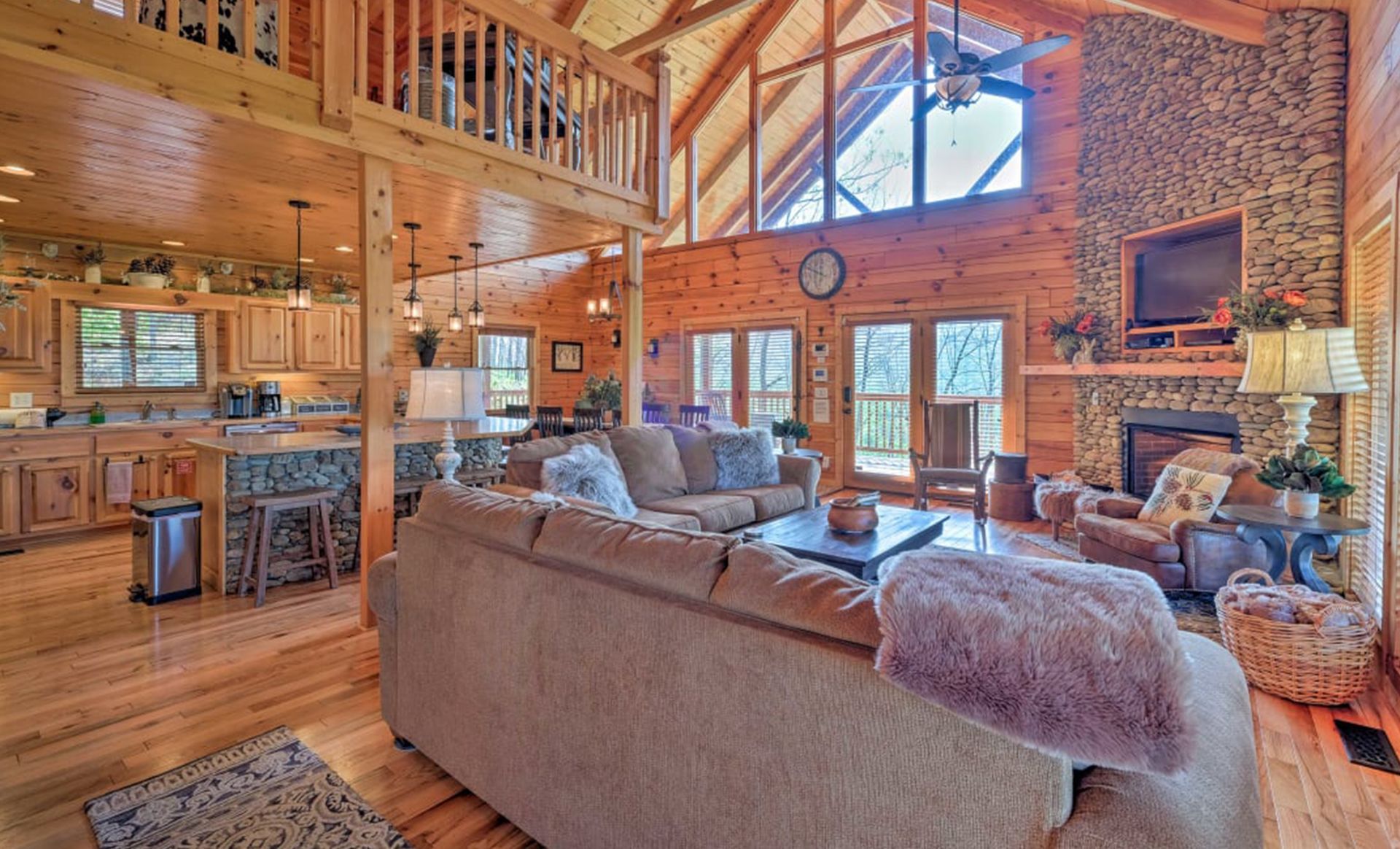 A living room filled with furniture and a fireplace in a log cabin.