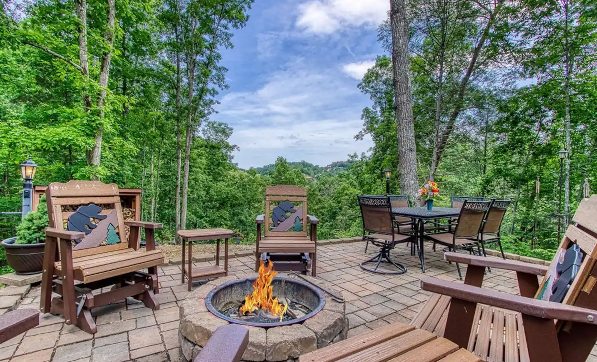 There is a fire pit on the patio with chairs around it.