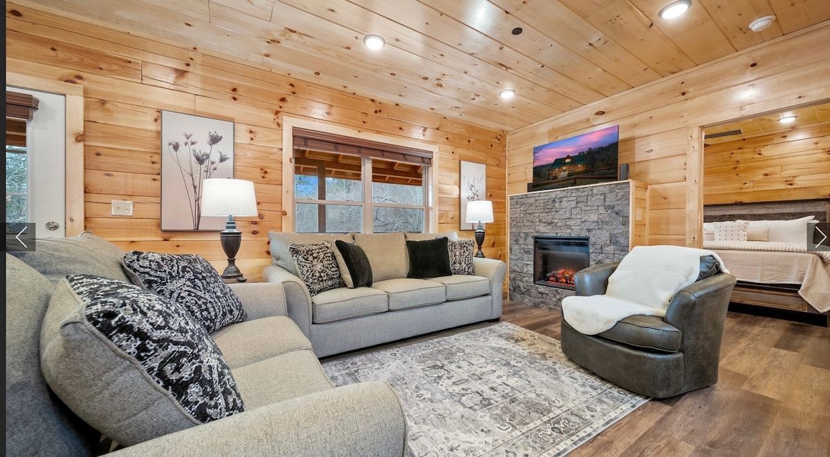 A living room filled with furniture and a fireplace in a log cabin.