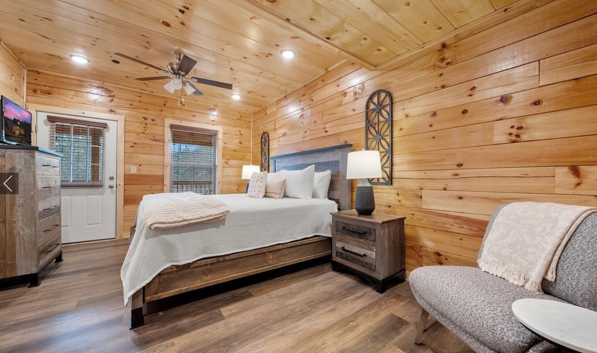A bedroom in a cabin with a king size bed and a chair.