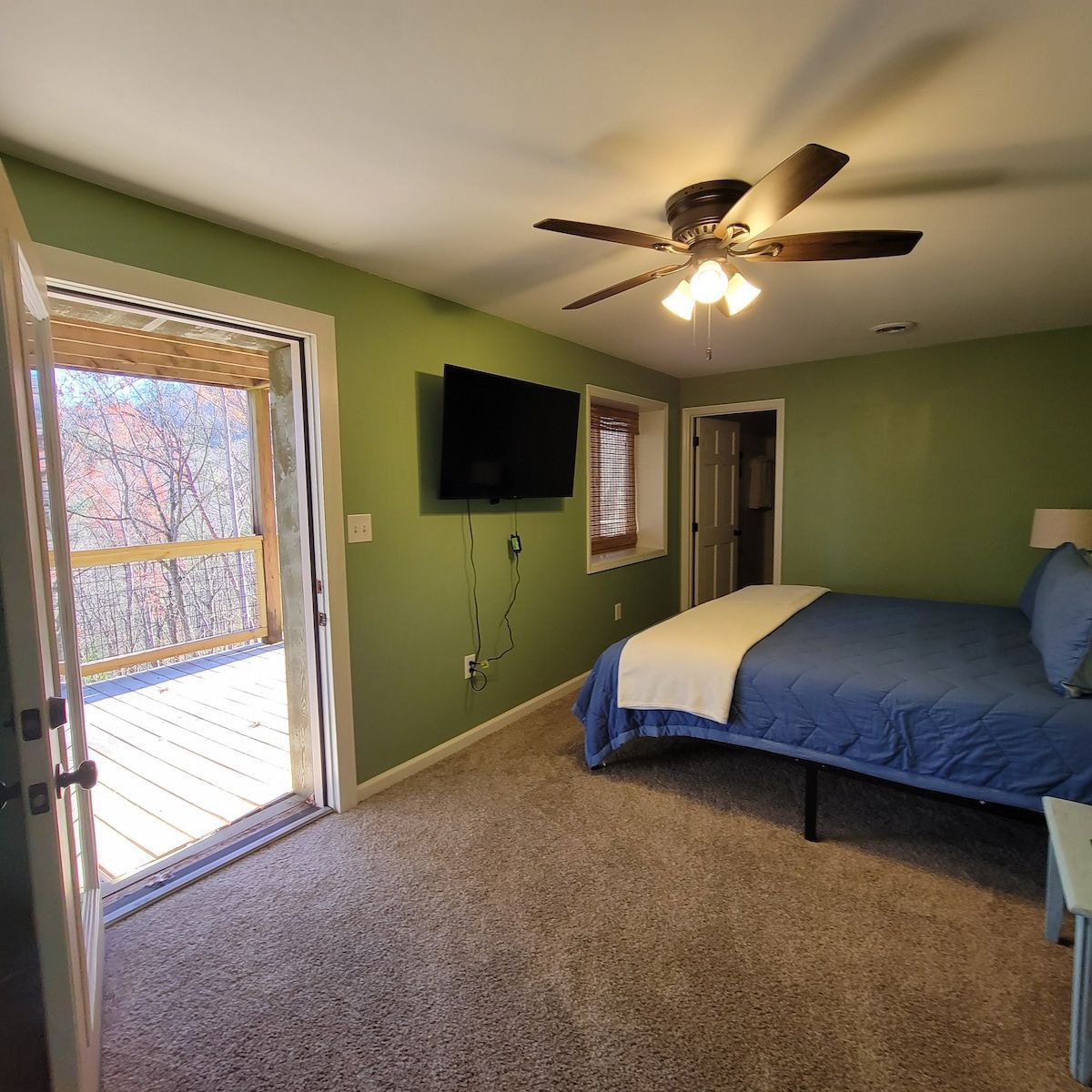 A bedroom with a bed , television and ceiling fan