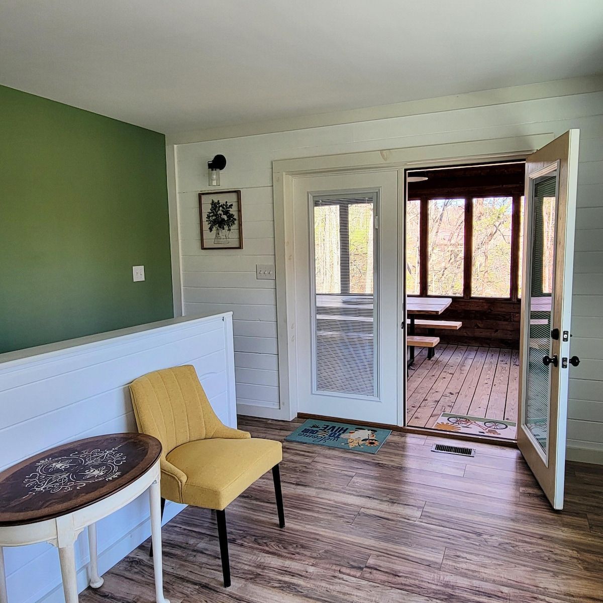 A living room with a yellow chair and a table.