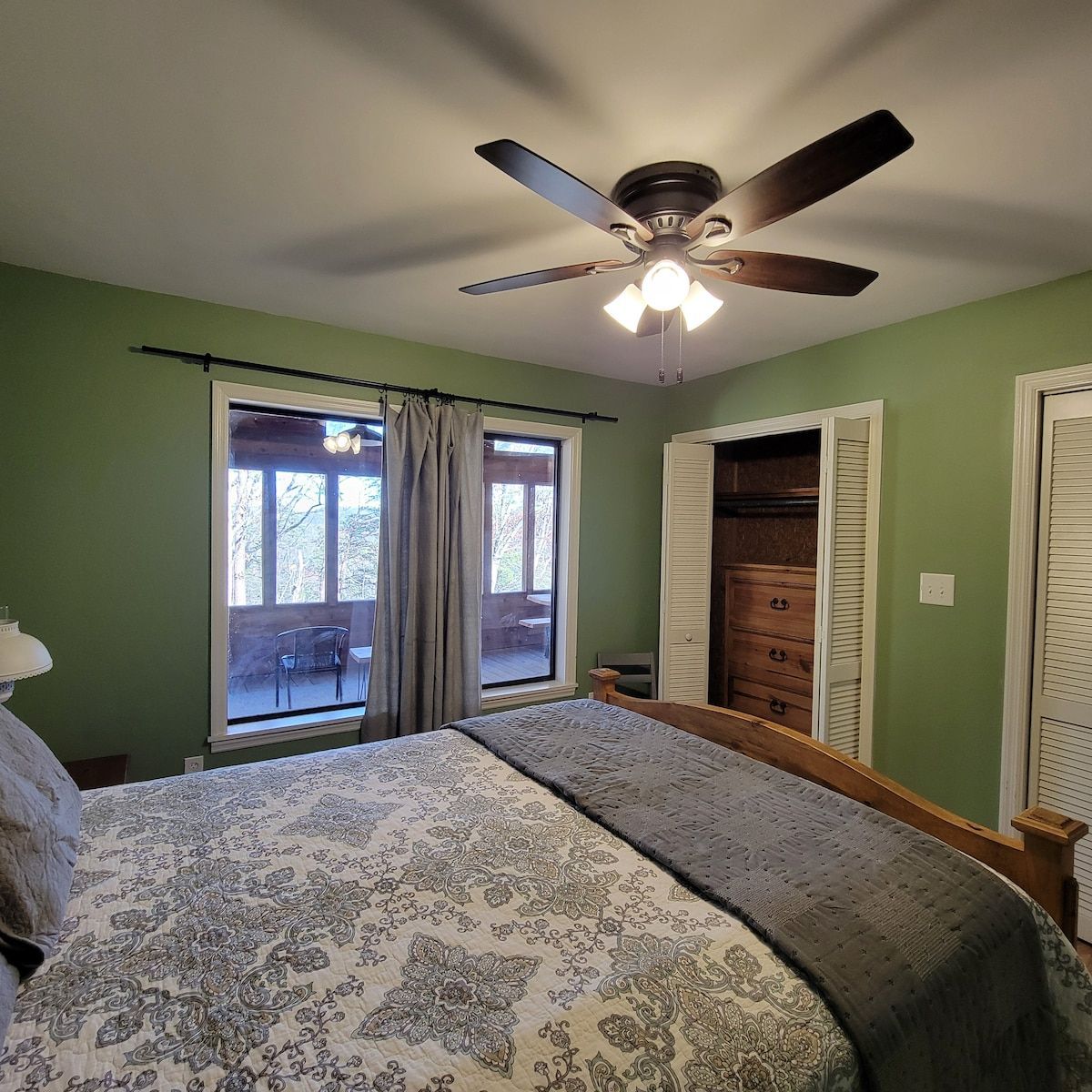 A bedroom with a bed and a ceiling fan