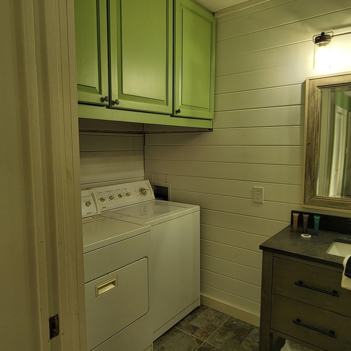 A laundry room with a washer and dryer and a mirror.
