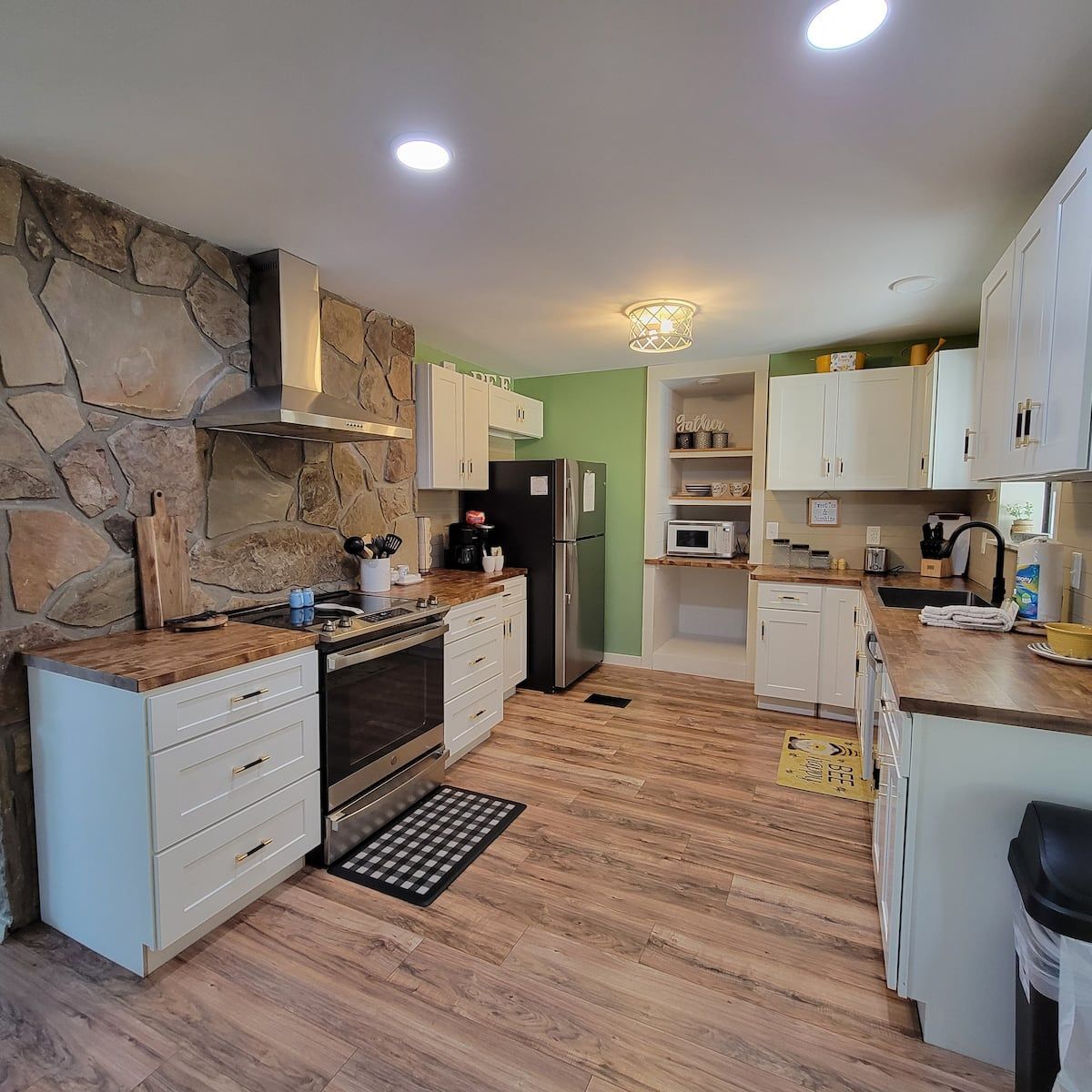 A kitchen with wooden floors and white cabinets