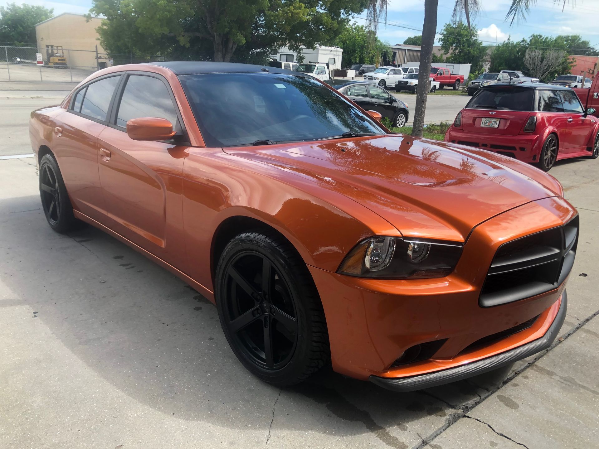 An orange dodge charger is parked in a parking lot.