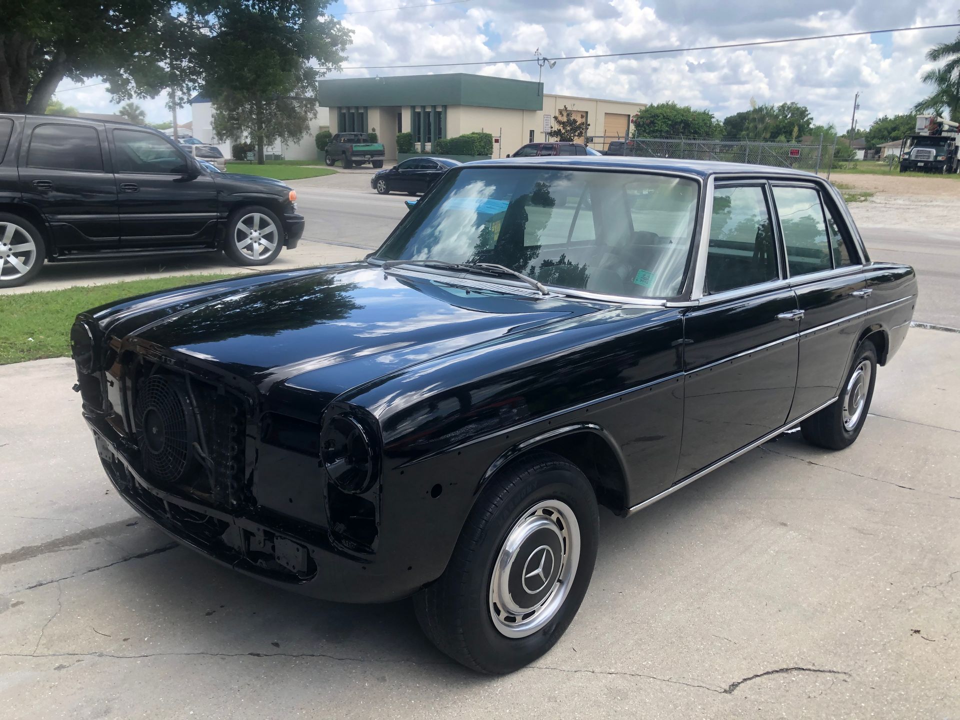 A black car is parked on the side of the road.
