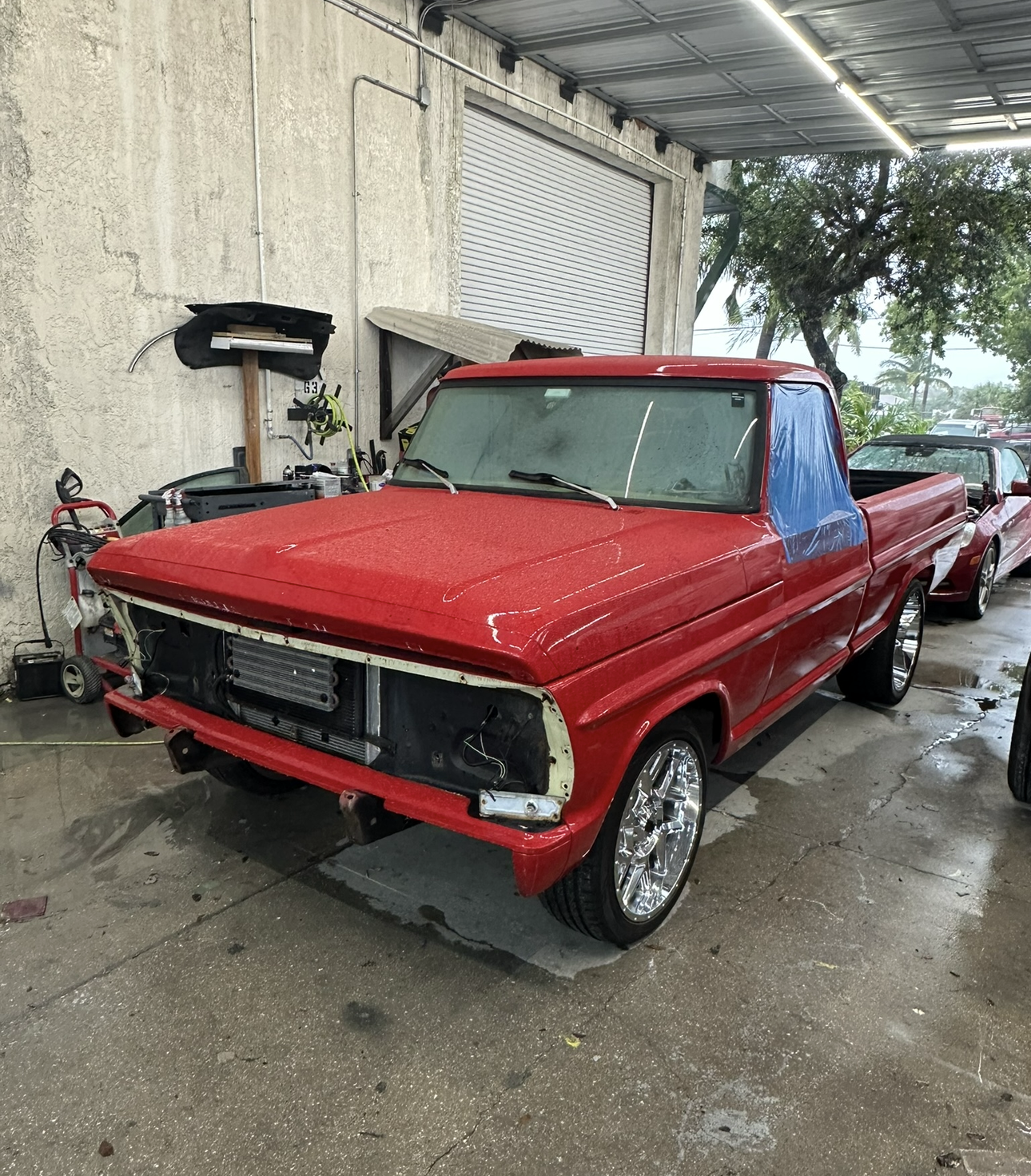A red pickup truck is parked in a garage.