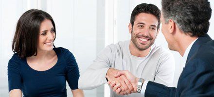 Happy couple seal a deal with their personal financial advisor