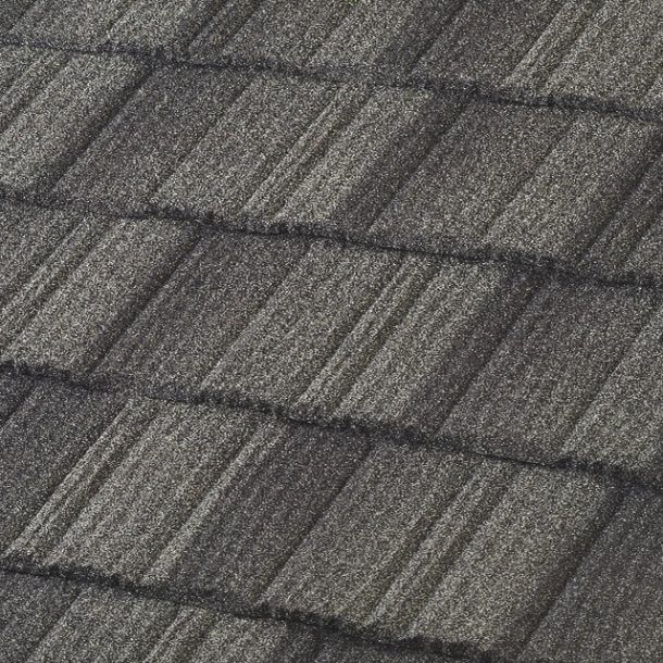 A close-up of dark grey, textured roof shingles with a staggered, wood-shake style pattern.