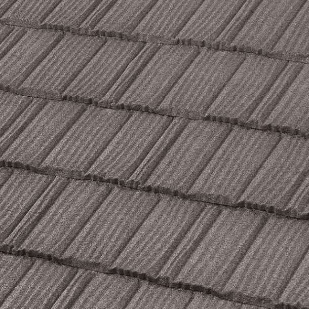 A close-up of dark grey, textured roof shingles with a repeating, layered vertical grain pattern.