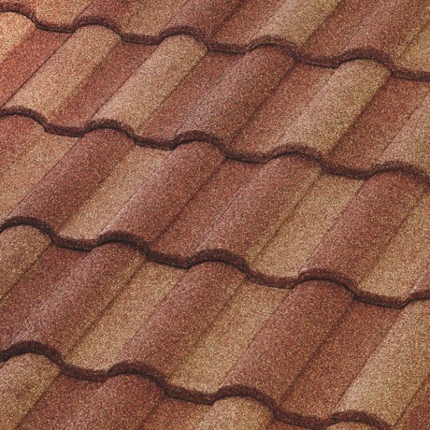 A close-up of overlapping, curved roof tiles featuring a textured, multi-tonal blend of earthy red and tan colors.
