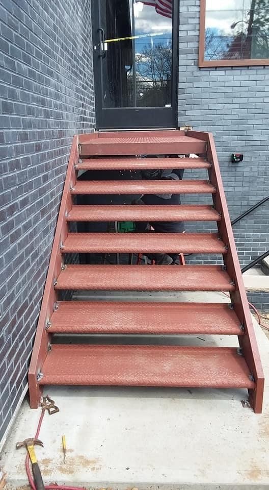 A set of red stairs leading up to a brick building