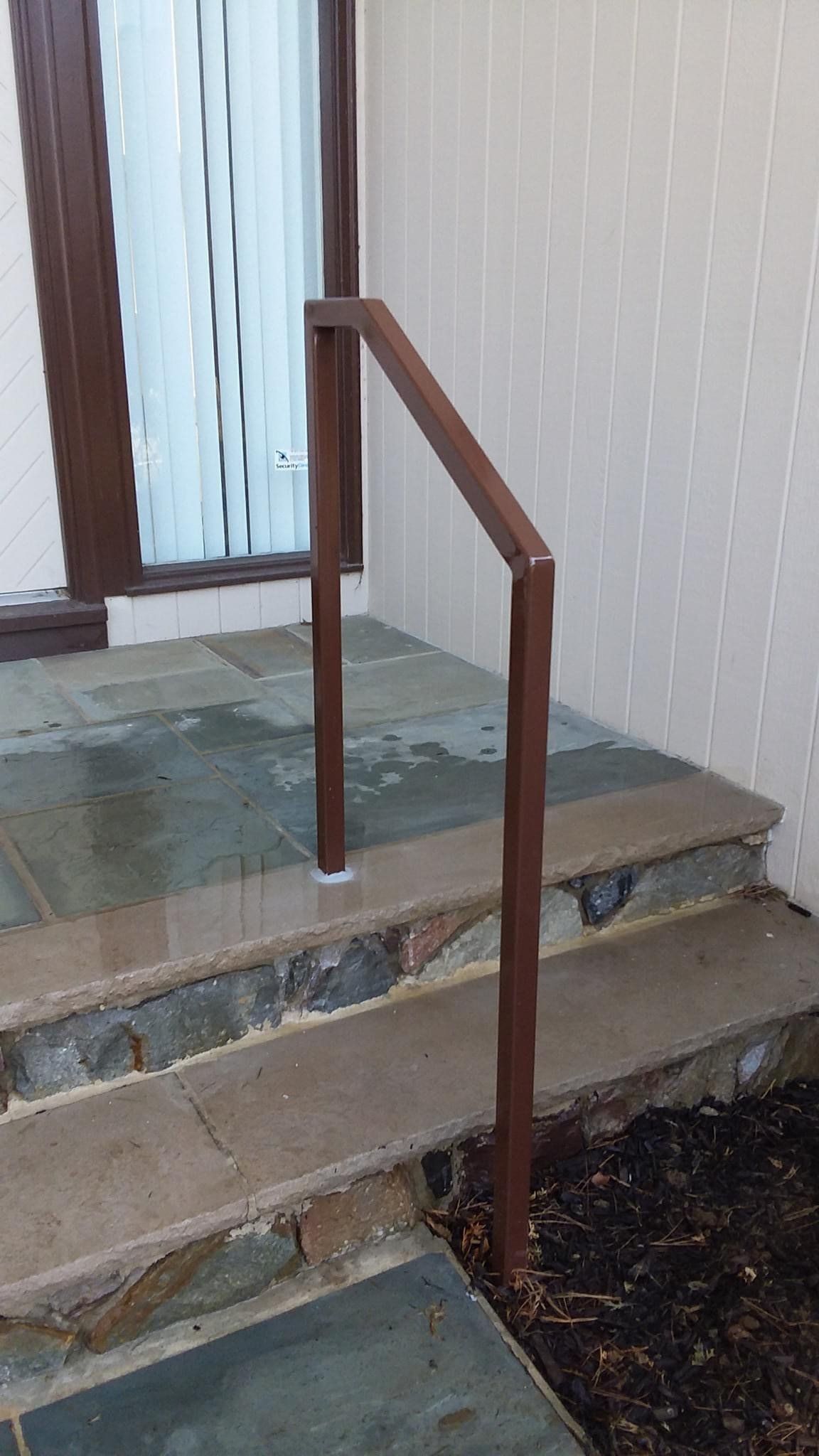 There is a railing on the side of the stairs leading up to the door