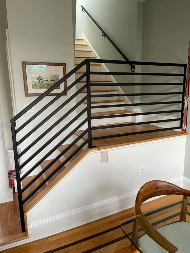A staircase with a black railing and wooden steps in a living room