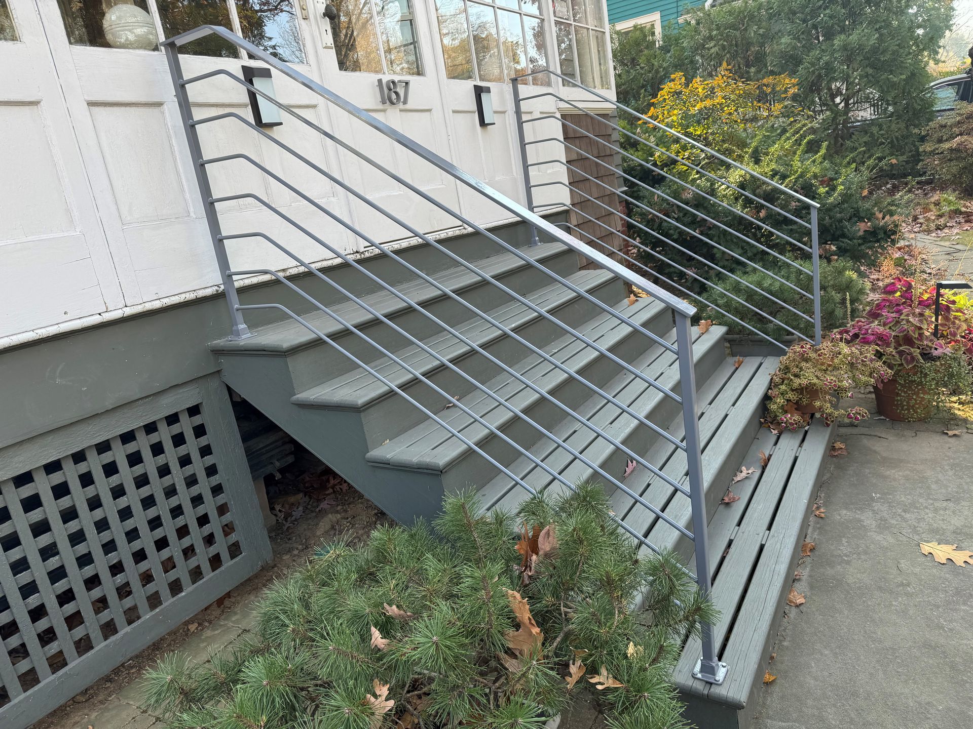 A set of stairs leading up to a house with a metal railing