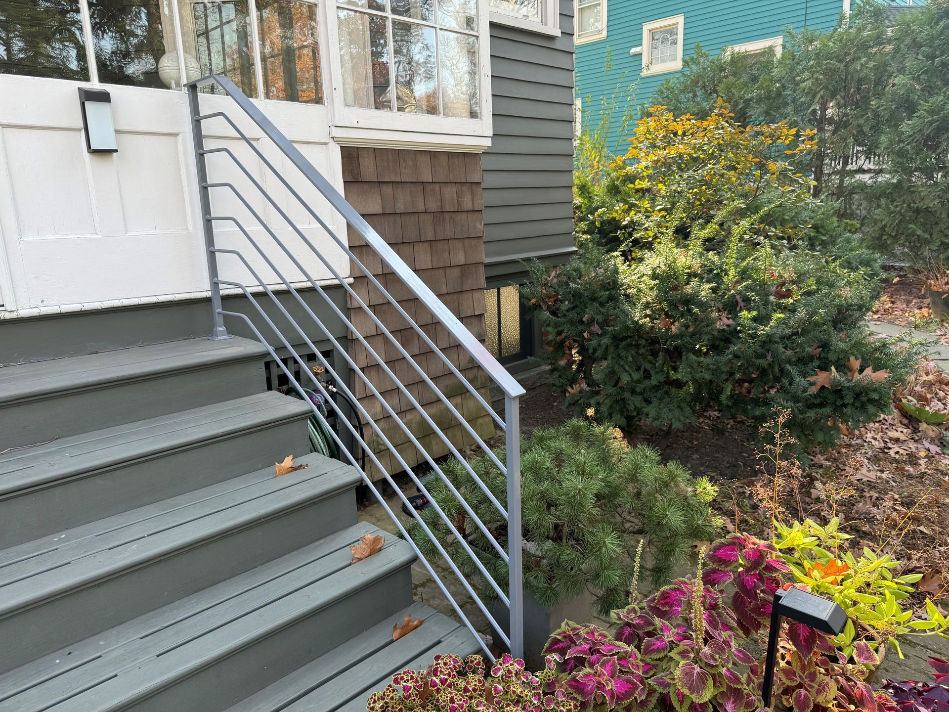 Set of stairs leading up to a house with a metal railing