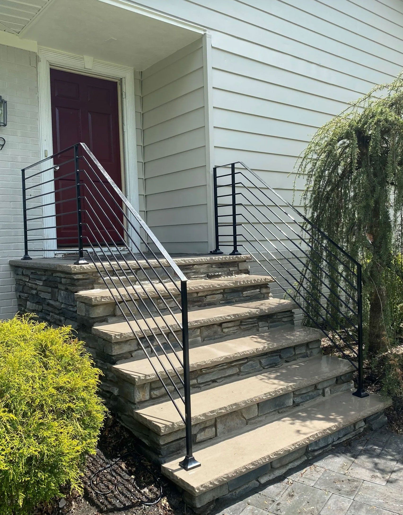 A set of stairs leading up to a house with a wrought iron railing