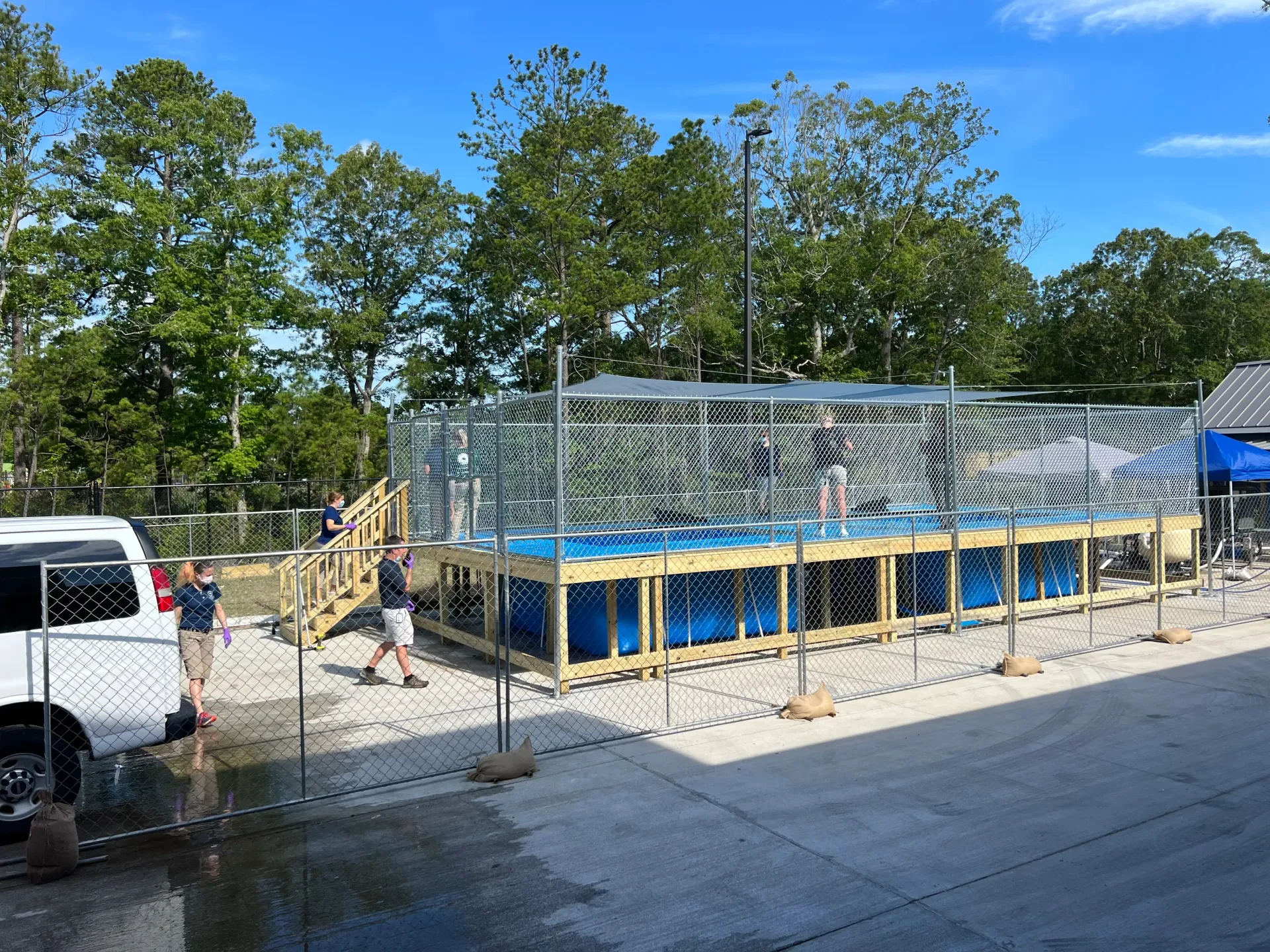 A large swimming pool is being built in a parking lot.