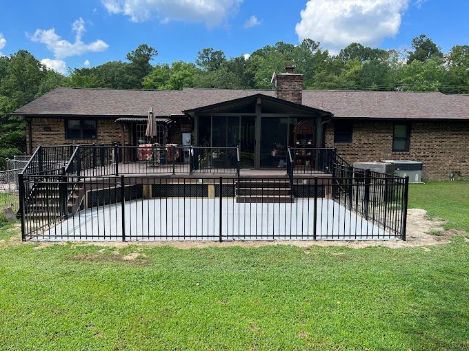 A house with a large deck and a fence around it.