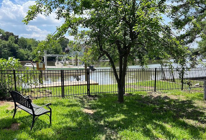 A park bench is sitting in the grass next to a lake.
