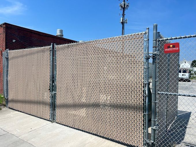 A chain link fence with a brick building in the background
