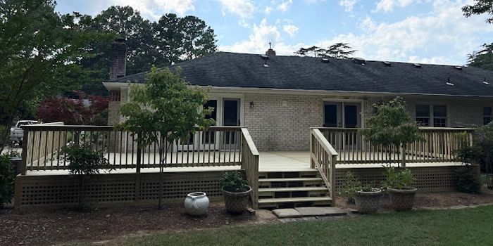 A house with a large deck and stairs in front of it.