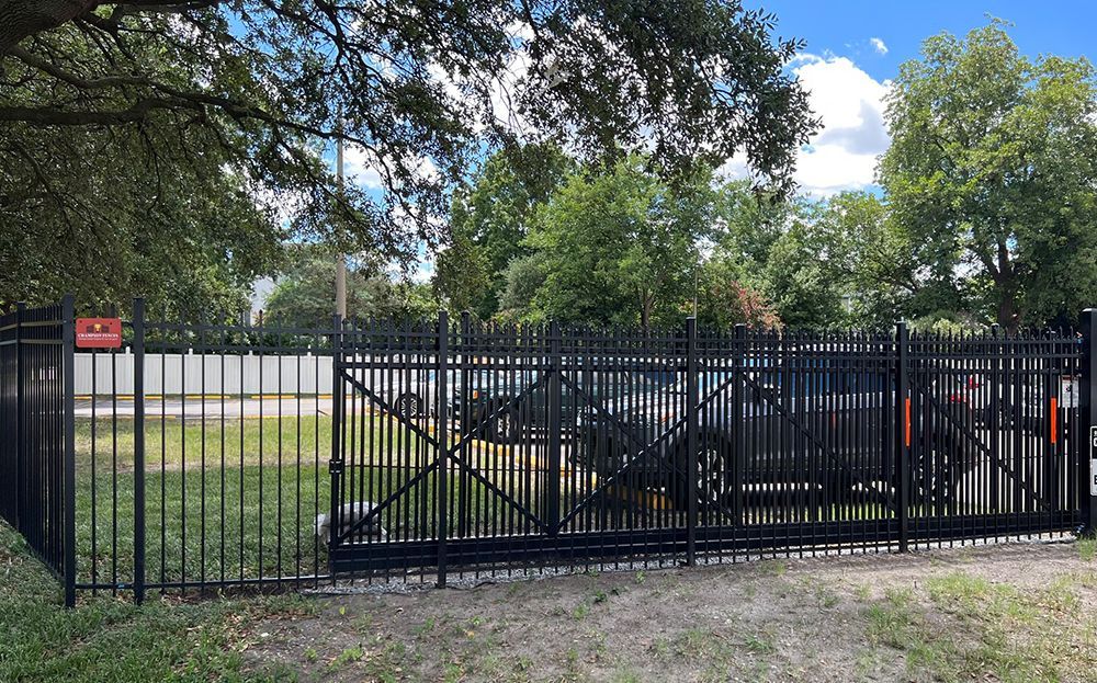 A black fence with a car parked behind it.