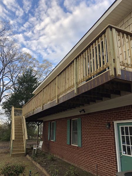 A brick house with a wooden deck and stairs