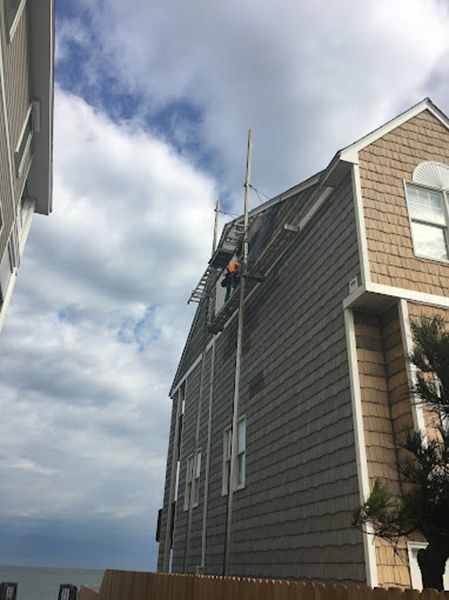 A man is working on the side of a house