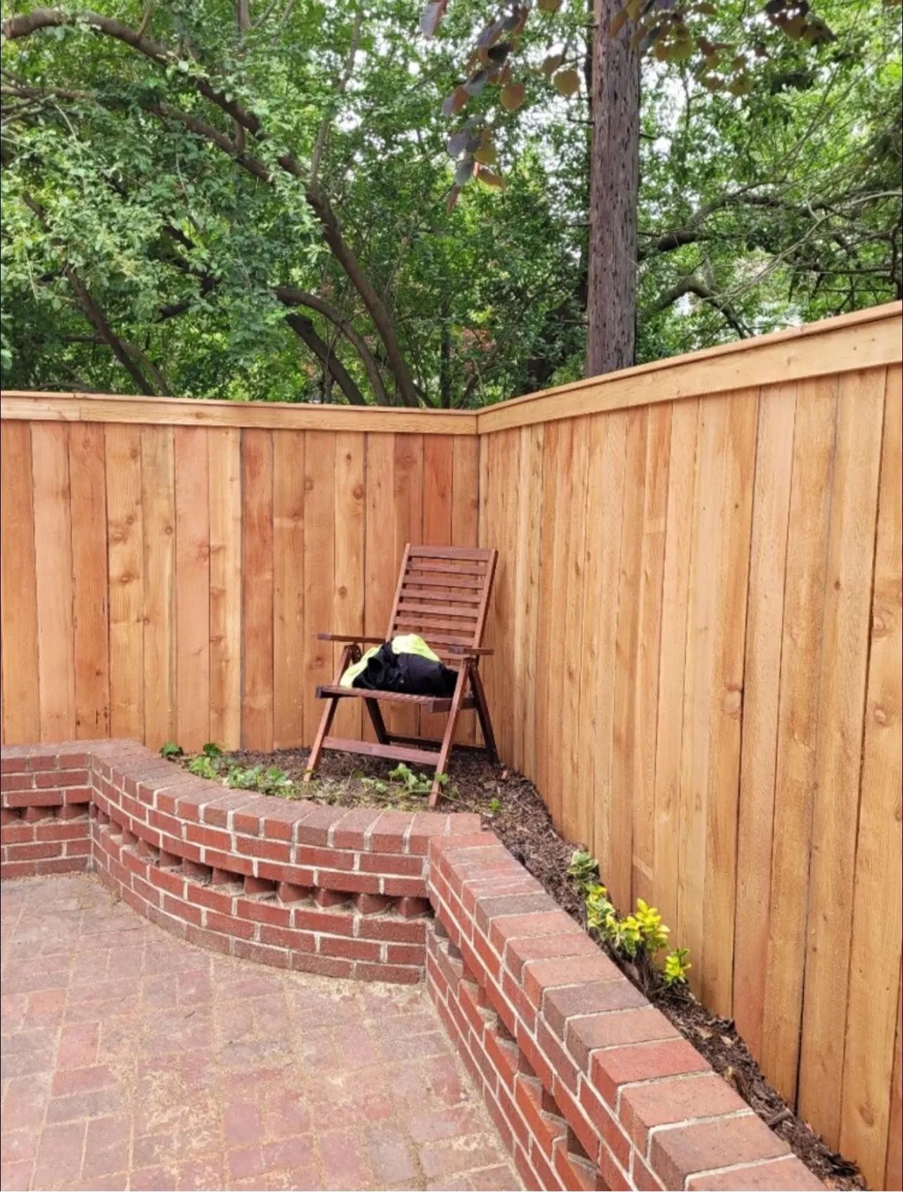 A wooden fence with a chair in the corner