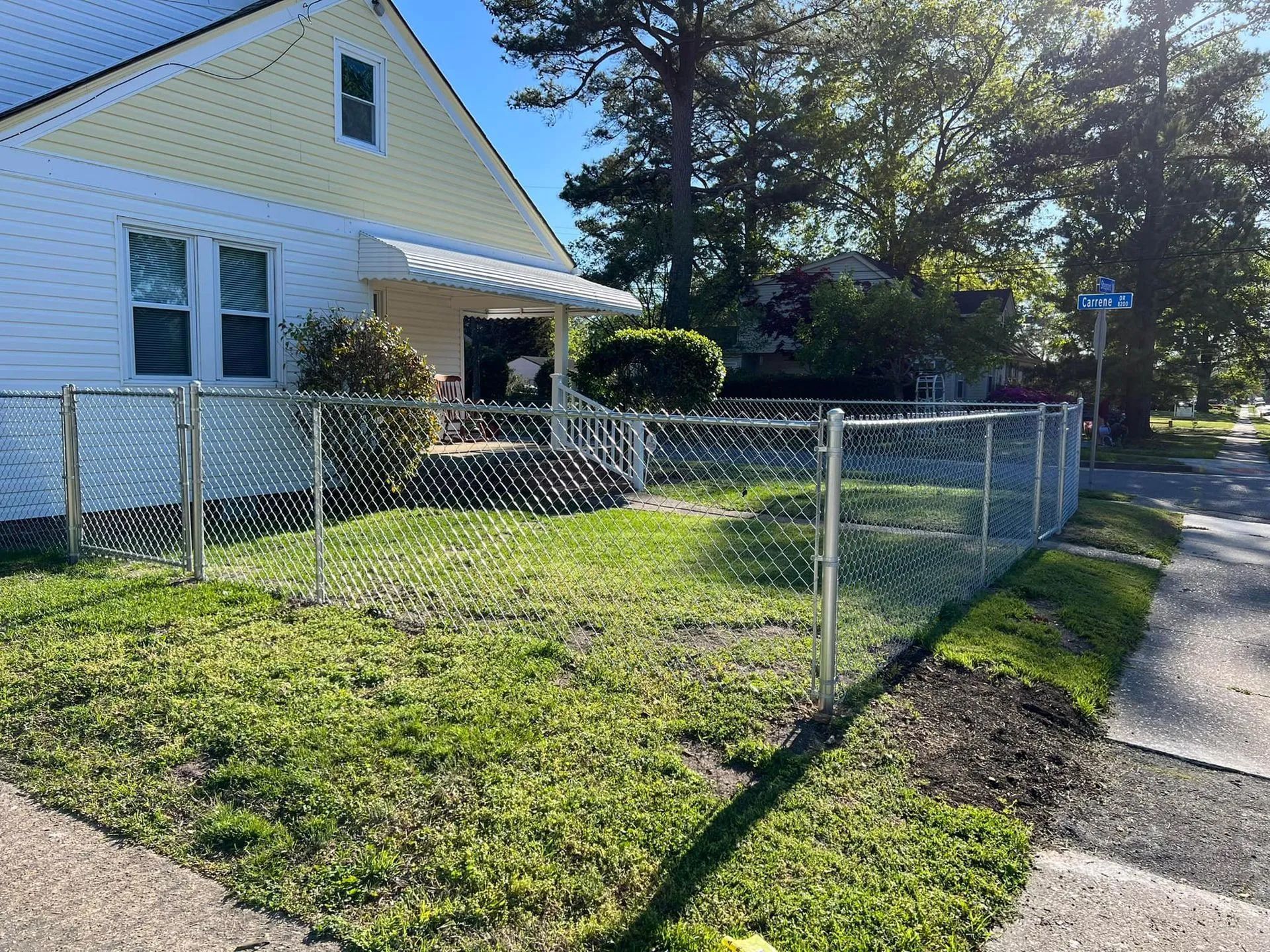 There is a chain link fence in front of a house.