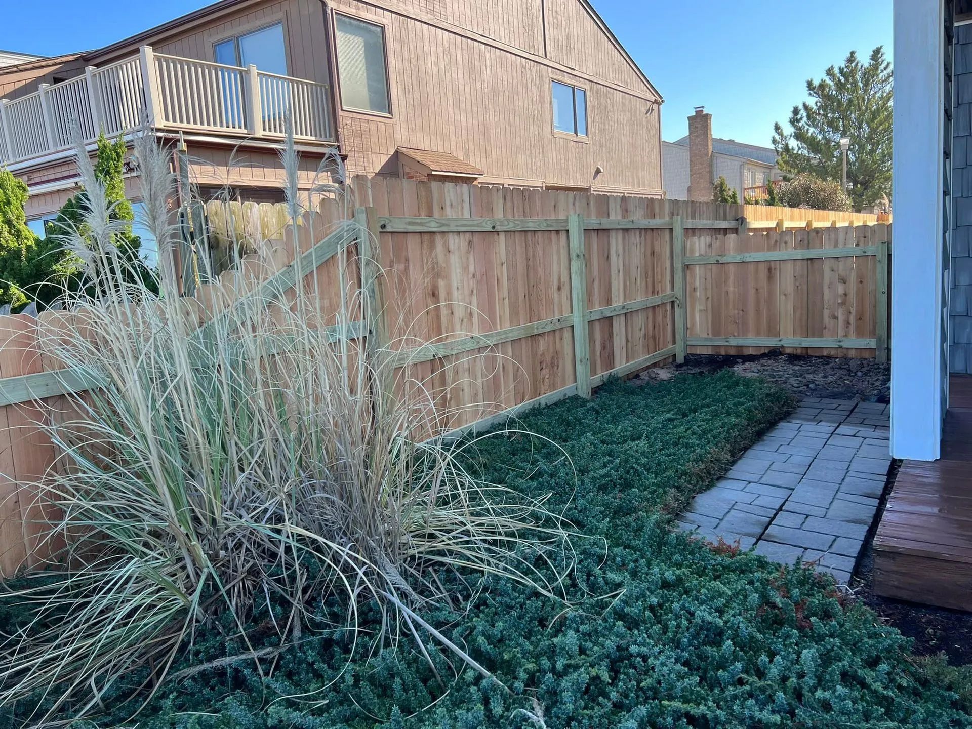 There is a wooden fence in the backyard of a house.
